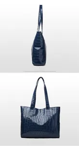 Detail view showing side and back of dark blue crocodile texture tote bag with long handles
