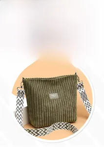 Detail of dark green corduroy tote bag showing vertical texture and patterned wide strap
