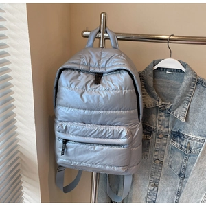 Detail of light blue quilted backpack with padded space cotton texture on display