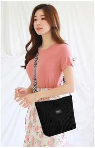 Detail of black corduroy tote bag with stylish wavy pattern wide shoulder strap