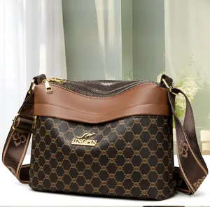 Close-up of brown textured crossbody bag with three zippers and kangaroo logo detail