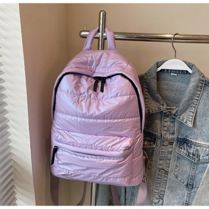 Detail of light purple quilted backpack showing soft puffer texture and zippered pockets