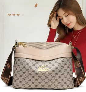 Close-up of triple gold zippers and floral woven strap on a vintage crossbody bag