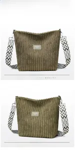 Detail of dark olive corduroy tote bag with vintage texture and patterned shoulder strap