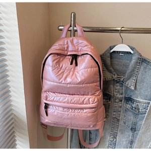 Close-up of pink quilted puffer backpack with soft nylon padding and zipper pocket