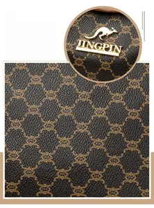 Close-up of brown patterned leather shoulder bag with gold kangaroo logo and zipper