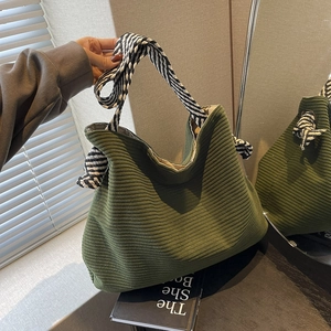 Green corduroy tote bag with striped shoulder strap for casual daily use and commuting