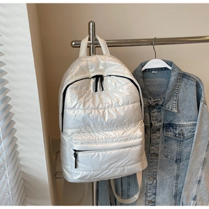 Detail of white quilted space cotton backpack with black contrast zippers and glossy finish