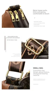 Close-up of golden zippers and adjustable logo strap on a vintage brown crossbody bag