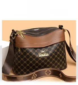 Close-up of triple-zipper storage compartments and gold hardware on crossbody bag