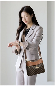 Detail of three-layer zipper compartments on a brown patterned crossbody shoulder bag