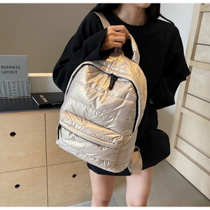 Champagne gold quilted backpack featuring metallic gloss fabric and wide nylon straps