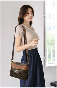Detailed view of triple zipper closure and patterned strap on brown crossbody bag