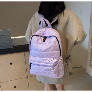 Rear view of a model wearing a light purple quilted puffer backpack with soft padding