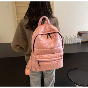 Detailed view of pink quilted puffer backpack with soft padded texture and zipper pocket