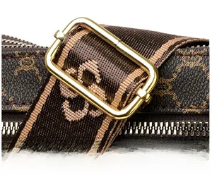 Detail of adjustable textile shoulder strap and golden metal buckle on crossbody bag