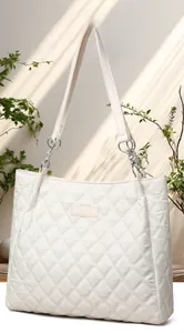 Détail du cabas matelassé ivoire avec logo Perfect Lily et chaînes argentées