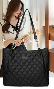 Détail du sac cabas matelassé noir montrant les coutures diamant et la chaîne en métal