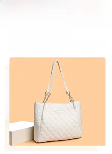 Gros plan d'un sac cabas matelassé blanc avec motif en losange et bandoulière chaîne
