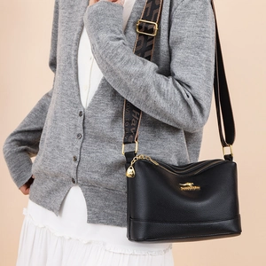 Black pebbled leather crossbody bag with jacquard strap and gold kangaroo logo