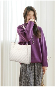 Détail d'un grand sac cabas blanc matelassé avec bandoulière en chaîne élégante pour femme