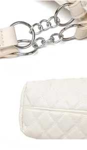 Détail de la boucle en métal argenté et des surpiqûres sur un sac cabas matelassé