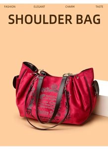 Detail of red velvet shoulder bag with black crown embroidery and silver chain links