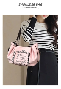 Detail of soft pink tote bag with retro crown print and metal chain strap on model
