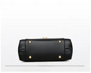 Detail of black lychee grain PU bag bottom with four gold metal protective feet studs