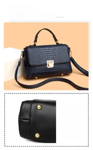 Detail view of navy blue leather handbag featuring crocodile texture and golden hardware feet