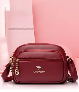 Detailed view of wine red lychee pattern leather crossbody bag with golden hardware