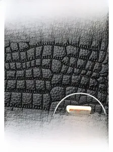 Detail of waterproof crocodile embossed black PU leather with golden metal square buckle