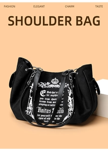 Detail of black canvas tote bag with white crown logo and decorative metal chain strap