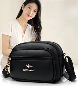Close-up of black litchi pattern leather crossbody bag with three golden zippers