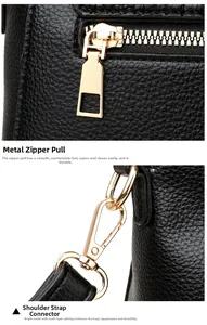 Detailed close-up of golden zipper puller and metal swivel hook on black leather bag