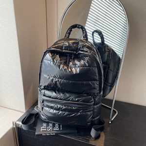 Quilted black puffer backpack with metallic glossy finish and large front zip pocket