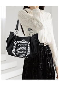 Detail of gothic crown print and leather chain strap on a black vintage tote bag