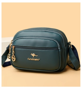 Detailed view of dark green leather crossbody bag with triple zippers and golden logo