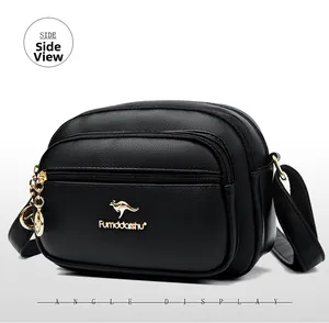 Detailed side angle display of black pebbled leather crossbody bag with triple zippers