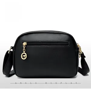 Back view of black pebble texture crossbody bag with gold kangaroo zipper pendant