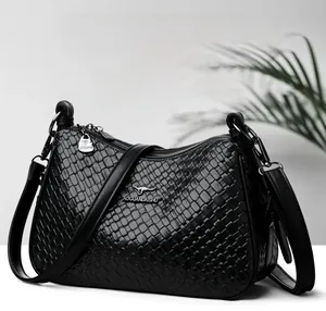 Dettaglio della borsa a tracolla in pelle PU nera intrecciata con logo a canguro in metallo