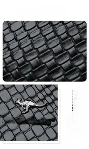 Dettaglio della pelle nera goffrata a trama e del logo metallico a canguro sulla borsa