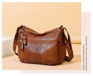 Close-up of vintage brown PU leather bag showing multi-pocket texture and bronze zippers