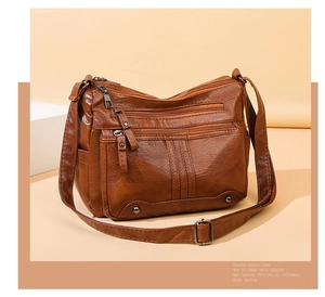 Detailed view of brown multi-zippered crossbody bag made of textured soft PU leather