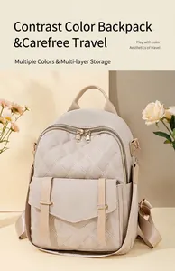 Detail eines cremeweißen Stepprucksacks mit Kontrastriemen und goldenen Reißverschlüssen