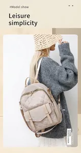 Modellpräsentation des beigen gesteppten Rucksacks mit goldenen Reißverschlüssen und Klapptasche