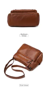 Detail view of brown leather bag showing multiple zippers and adjustable shoulder strap
