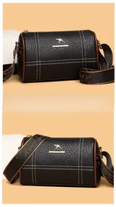 Détail du sac polochon en cuir noir grainé avec logo métallique et bandoulière