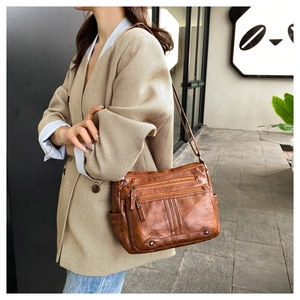 Brown soft leather crossbody bag featuring three front zippers and side pockets