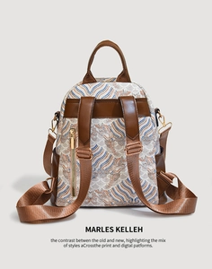 Close-up of vintage patterned backpack with brown leather trim and gold metal zippers